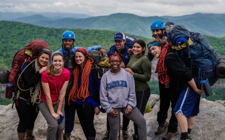 a group of gap year students pause for a photo on an overlook of the blue ridge mountains on an outward bound course